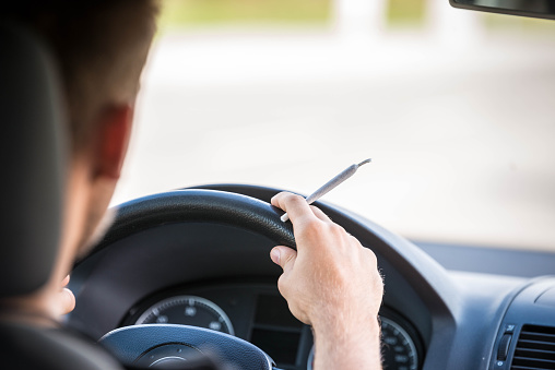 Man driving and smoking joint